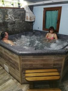 a man and a woman in a hot tub at Hotel Rai in Koprivshtitsa