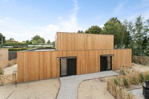 a timber clad house with two garage doors at Chalet Florette in Koksijde