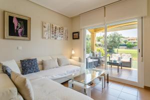 een woonkamer met een bank en een glazen tafel bij Chalet Bonalba Golf in Alicante