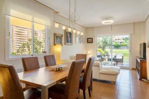 comedor y sala de estar con mesa y sillas en Chalet Bonalba Golf, en Alicante