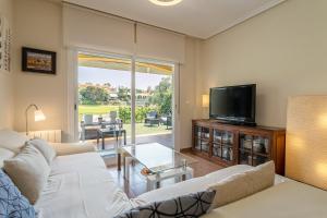 uma sala de estar com um sofá e uma televisão em Chalet Bonalba Golf em Alicante