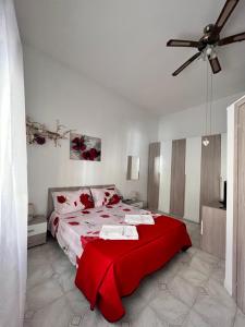 - une chambre avec un lit et une couverture rouge dans l'établissement Casa Planet, à Montalbano Ionico