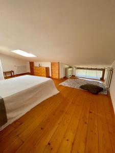 a bedroom with a large bed and a wooden floor at La Casa nel Borgo in Fosdinovo