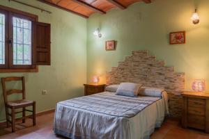a bedroom with a bed and a stone wall at CASAS RURALES LA TOBICA in Yeste