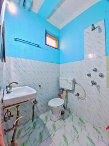 a bathroom with a white toilet and a sink at Lumbini Garden Lodge in Rummindei