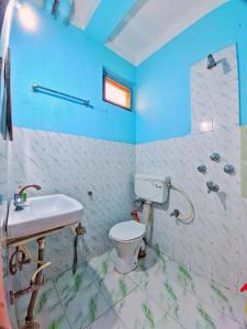 a bathroom with a white toilet and a sink at Lumbini Garden Lodge in Lumbini +23 photos