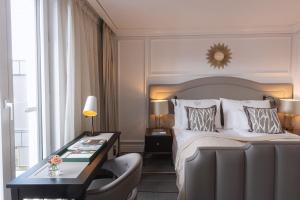 um quarto de hotel com uma cama e uma secretária com uma cadeira em Britannia Hotel em Trondheim