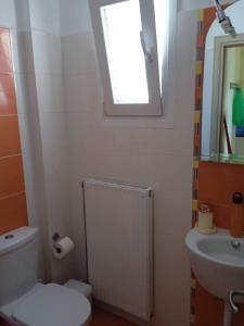 a bathroom with a toilet and a sink and a window at Leros 'Sundown' Guest house in Gourna +24 photos