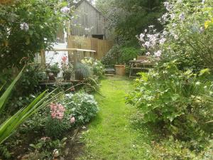 d'un jardin avec des fleurs et une clôture en bois. dans l'établissement Tranquil wood cabin set in a beautiful orchard, à Penzance