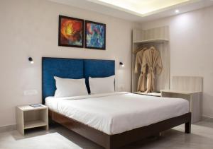 a bedroom with a large bed with a blue headboard at Sandbanks Beach Resort in Arambol