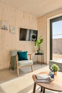 ein Wohnzimmer mit einem Stuhl und einem TV an der Wand in der Unterkunft Chalet Florette in Koksijde
