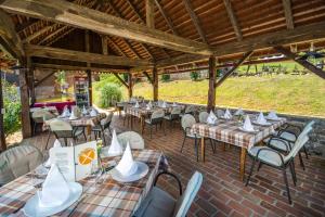 an outdoor patio with tables and chairs and tablesearcher at Hotel Srakovcic Heart of Nature in Ribnik