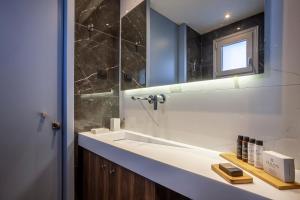 een badkamer met een wastafel en een spiegel bij Violin Glam Apartments by BiNoBi! in Thessaloniki +57 foto's