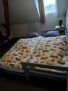 a bed with a comforter on it in a bedroom at B2 Appartement entier centre ville tout confort in Courtenay