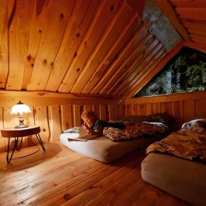 a person laying on a bed in a room at Viking house in the tree! Jacuzzi, Sauna,apkure! in Līči