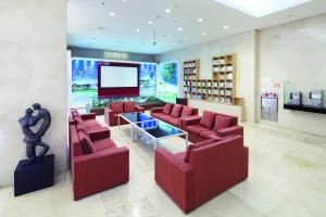 a living room with red chairs and a television at Hanwha Resort Pyeongchang in Pyeongchang