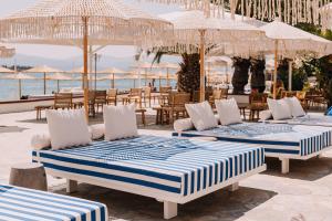 eine Gruppe von Betten auf einer Terrasse in der Nähe des Ozeans in der Unterkunft Brown Beach Evia Island, All Inclusive in Eretria, a member of Brown Hotels in Eretria