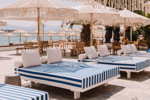 a group of beds sitting on a patio near the ocean at Brown Beach Evia Island, All Inclusive in Eretria, a member of Brown Hotels in Eretria