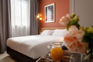 a hotel room with a bed and a table with a drink at Corner-Set Cholet Centre in Cholet