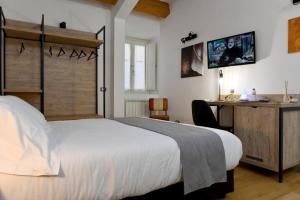 Schlafzimmer mit einem Bett, einem Schreibtisch und einem TV in der Unterkunft Ballarooms B&B Palermo Centro in Palermo