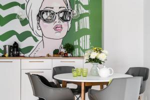 a table with a drawing of a woman wearing sunglasses at Grand Apartments - Brabank Apartments in Gdańsk