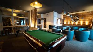 a room with a pool table and chairs at Hôtel Club "Les Carrettes" in Valmeinier
