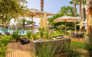 a patio with chairs and umbrellas next to a pool at Royal Azur Thalassa in Hammamet
