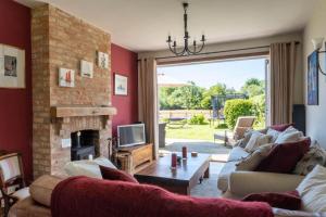a living room with a couch and a fireplace at Heather Cottage in Brockenhurst