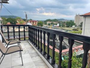 a balcony with chairs and a view of a city at Зелената къща in Hisarya