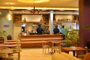 um restaurante com pessoas de pé no bar em Tenda Suites and Restaurant em Entebbe