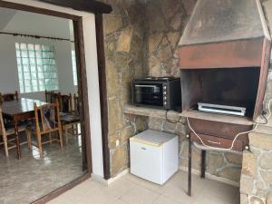 a kitchen with a microwave and a table in a room at Зелената къща in Hisarya