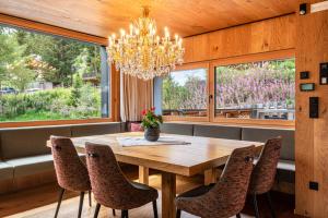 a dining room with a table and chairs and a chandelier at Chalet Bergfreund in Valdaora