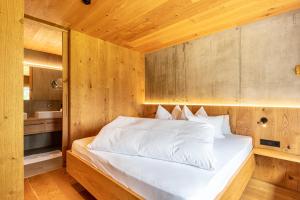 a bedroom with a bed in a wooden room at Chalet Bergfreund in Valdaora