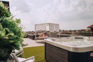 uma banheira de hidromassagem no telhado de uma casa em Hotel Glory em Oradea
