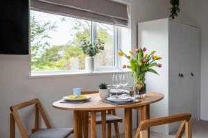 a dining room table with chairs and a window at Little Nye in Milford on Sea