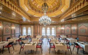 a dining room with a chandelier and tables and chairs at Royal Azur Thalassa in Hammamet