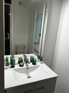Neoresid Paris-Gagny في Gagny: حمام مع حوض أبيض ومرآة