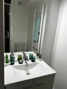 un bagno con un lavandino bianco e uno specchio di Neoresid Paris-Gagny a Gagny
