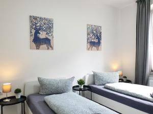 a bedroom with two beds and paintings on the wall at Apartments an der Kreuzstraße in Braunschweig