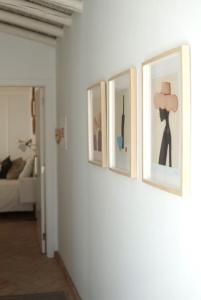 tres fotos en una pared en una sala de estar en A Casa de Cima - Cacela Velha en Vila Nova de Cacela