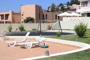 una terraza con 2 tumbonas y una piscina en Garajau Terrace Orchids, en Caniço