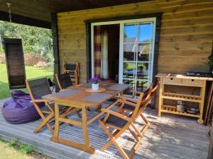 una mesa de madera y sillas en el porche de una cabaña en Norwegian saunahouse en Haapse