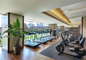 a gym with rows of treadmills and a lot of people in the background at Shangri-La Tianjin in Tianjin