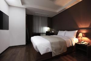 a bedroom with a large bed and a flat screen tv at Urban Place Gangnam in Seoul