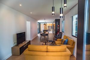 ein Wohnzimmer mit 2 gelben Sofas und einem TV in der Unterkunft Populo's Place in Ponta Delgada