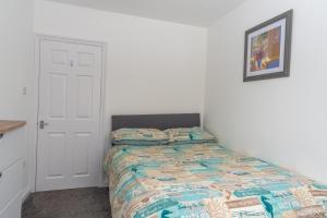 a bedroom with a bed with a quilt on it at Ivy Cottage with Sea Views in Bideford
