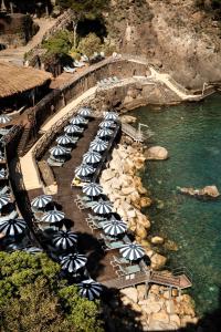 un gruppo di ombrelloni su una spiaggia accanto all'acqua di Mezzatorre Hotel & Thermal Spa a Ischia