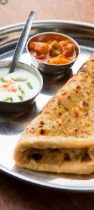 two slices of pizza on a plate with bowls of soup at kings villa Jaisalmer in Jaisalmer