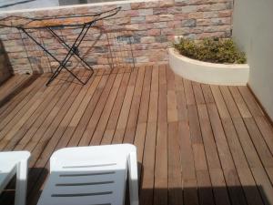 a wooden deck with a chair and a plant at Apartamentos Santiago - Maio in Vila do Porto
