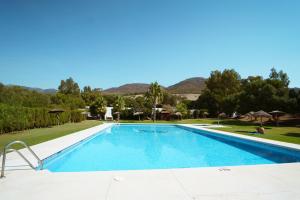 a swimming pool in a resort with mountains in the background at Kampaoh Valdevaqueros in Tarifa
